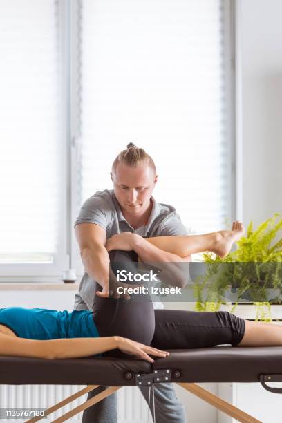 Physiotherapist Massaging Young Womans Legs Stock Photo - Download Image Now - Hip - Body Part, Pain, Women