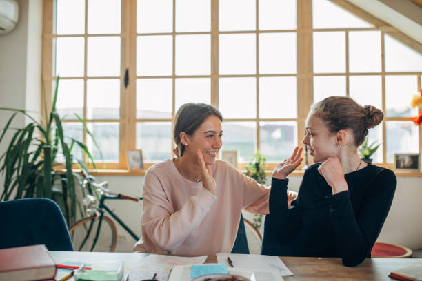 istock Private teacher helping girl doing homework 1135767458