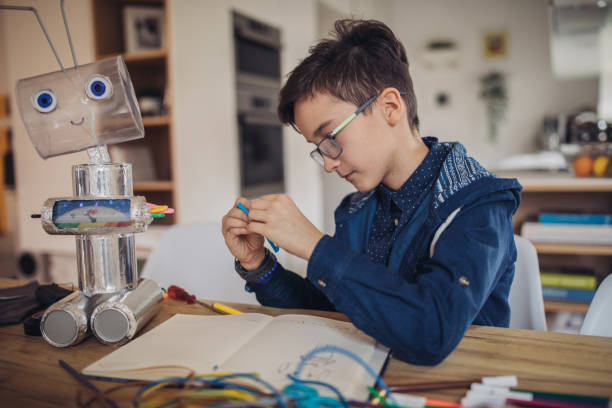 istock Boy making robot toy of recycling material 1135770301