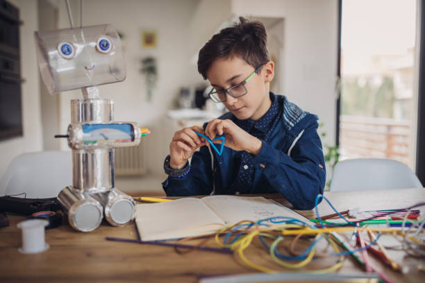 istock Boy making robot toy of recycling material 1135770368