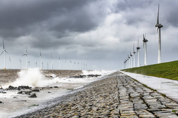 istock Wind turbines in an offshore wind park during a storm with big waves hitting the shore 1135771547
