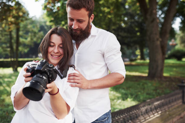 istock Smiling couple viewing pictures on the camera 1135771603