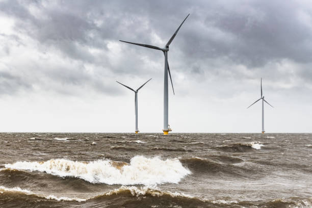 turbiny wiatrowe w morskim parku wiatrowym podczas burzy z dużymi falami uderzającymi w brzeg - noordoostpolder zdjęcia i obrazy z banku zdjęć