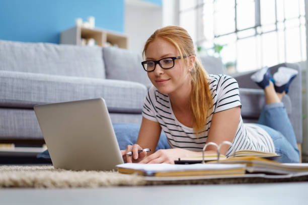 istock Smiling young female student studying at home 1135771682