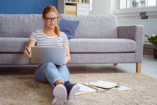 Young woman studying at home in the lounge