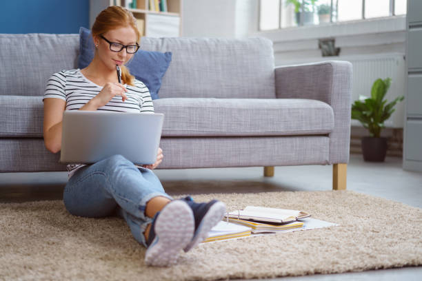 Studious young woman working at home stock photo