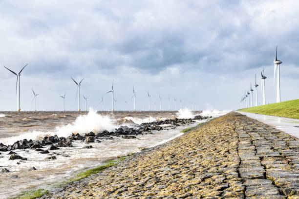 istock Wind turbines in an offshore wind park during a storm with big waves hitting the shore 1135773630