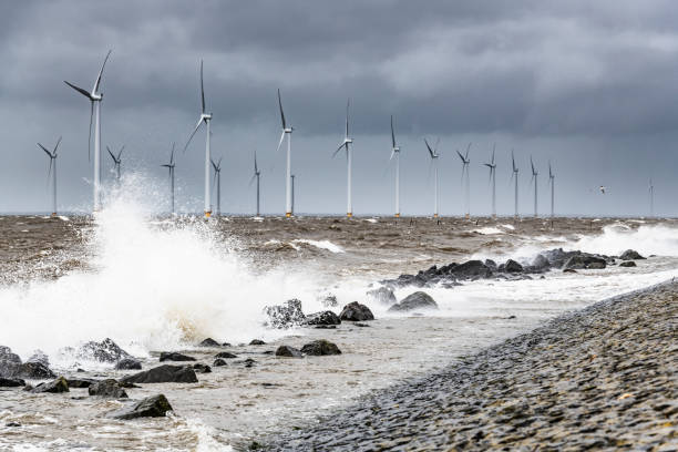 istock Wind turbines in an offshore wind park during a storm with big waves hitting the shore 1135773660