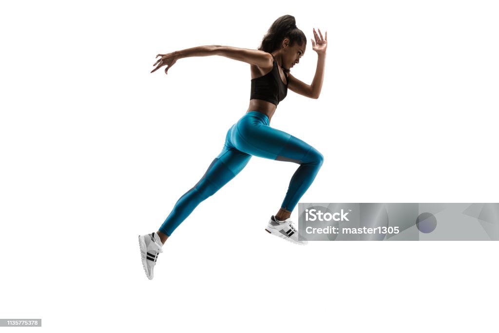 Young african woman running or jogging isolated on white studio background. Young african woman running isolated on white studio background. One female runner or jogger. Silhouette of jogging athlete Running Stock Photo
