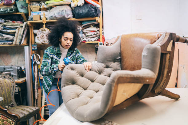afro weiblicher refurbishing chair in upholstery workshop - polstermöbel stock-fotos und bilder