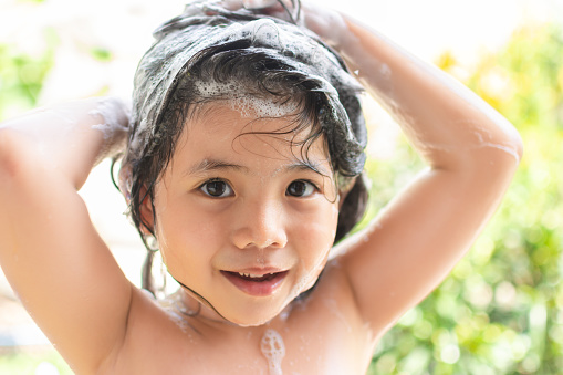 Close up Portrait Cute Little Asian Girl is Smiling happily when bathing And looking at the camera.