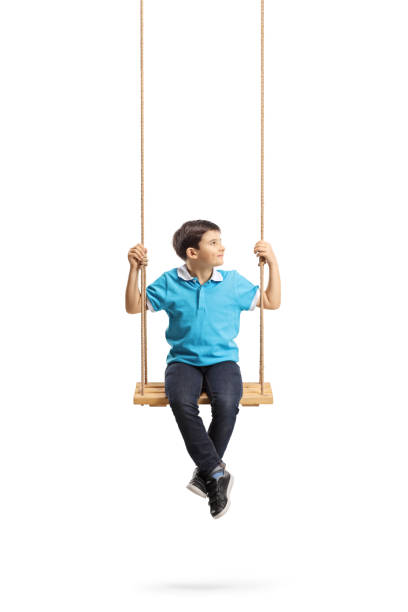 istock Little boy sitting on a swing and looking to the side 1135778135