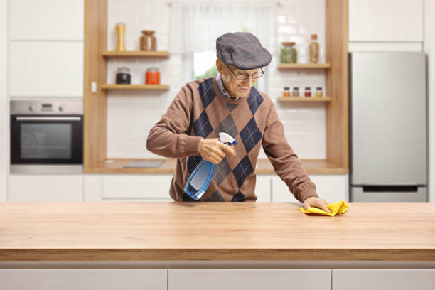 anziano che pulisce un bancone di legno in cucina - domestic kitchen towel dish cloth rag foto e immagini stock