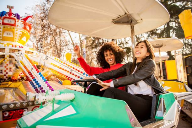 istock Two friends riding amusement park ride 1135779881