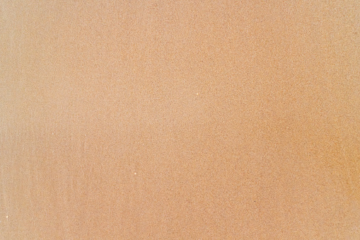Smooth brown sand on the beach texture. Perfect for background.