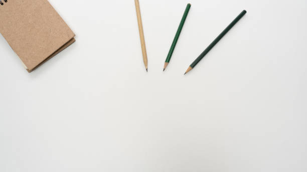 istock Office desk table with  pencil and notebook close up Top view copy space 1135784639