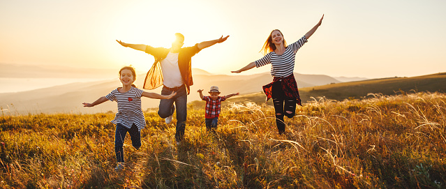 Happy family: mother, father, children son and  daughter on nature  on sunset