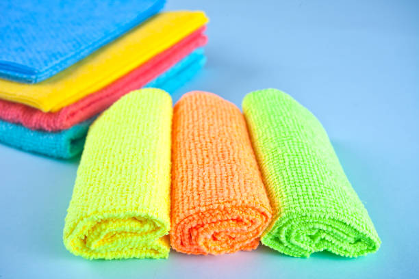 set di asciugamani e spruzzatori per la pulizia in microfibra su sfondo blu - domestic kitchen towel dish cloth rag foto e immagini stock