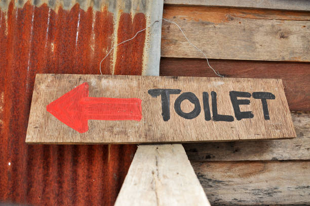 Signs to the toilets, which was written on a sheet of plywood.