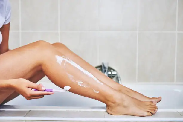 Cropped shot of an unrecognizable woman shaving her legs