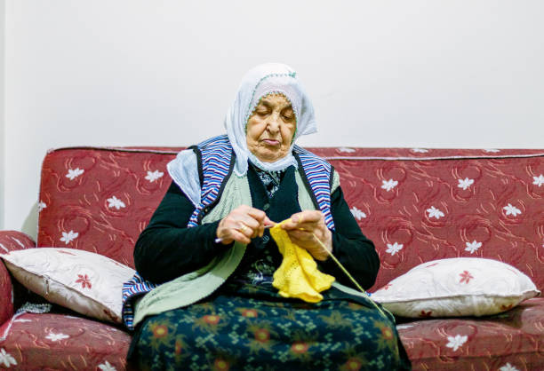Elderly woman knitting at home