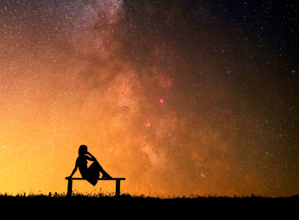 istock Dreaming girl sitting under the stars 1135788321