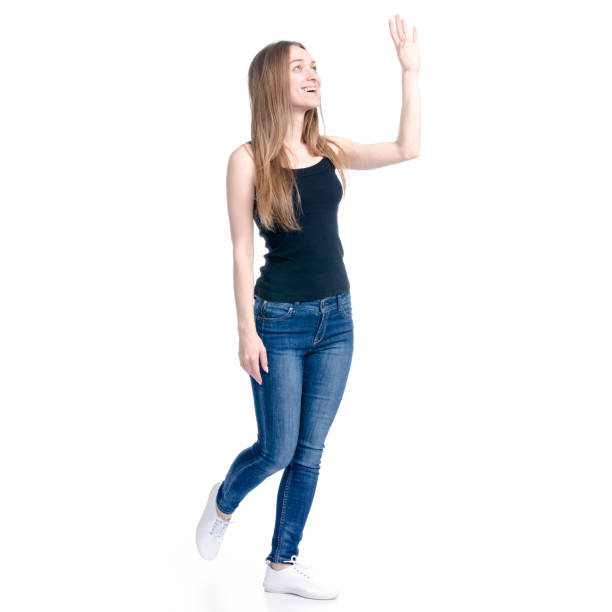 istock Woman in jeans waving hand smiling 1135788838