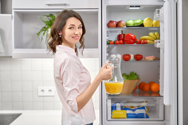 istock Woman opening refrigerator, holding pitcher with juice. 1135789208