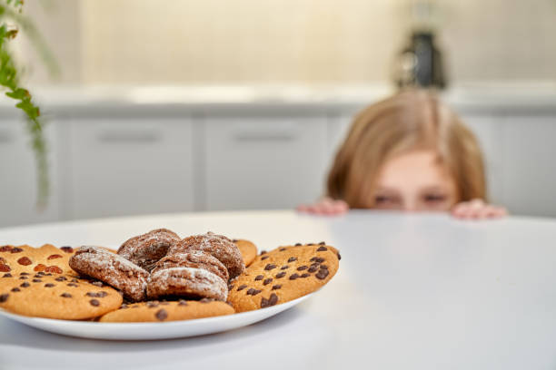 istock American cookies on plate, child hiding behind table. 1135789215