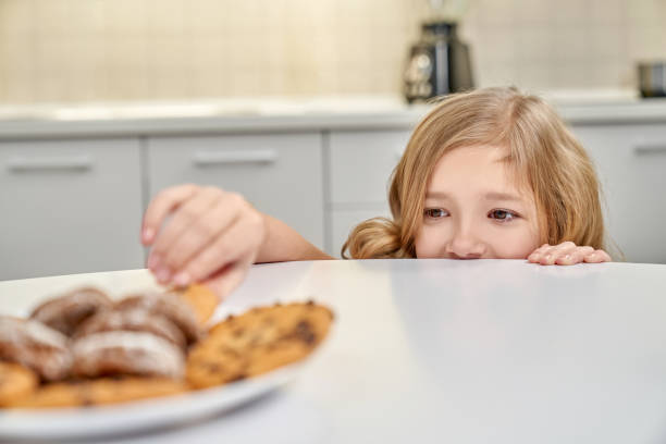istock Child secretly taking american cookies from plate. 1135789221