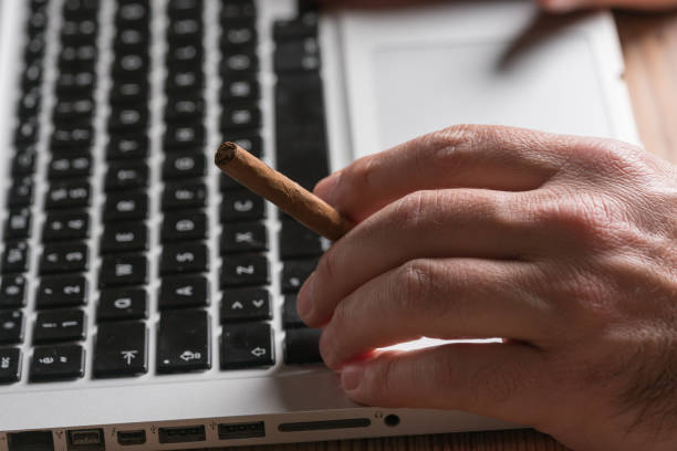 istock Man working on a laptop at home office,with a cigarette 1135791846