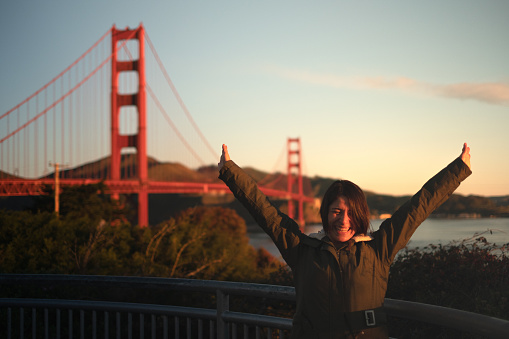 portait of happy girl arms wide open at Golden gate bridge in San Francisco