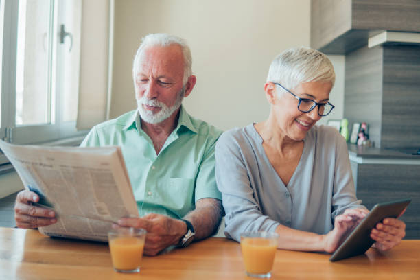 istock Senior couple with digital tablet and newspaper 1135796872