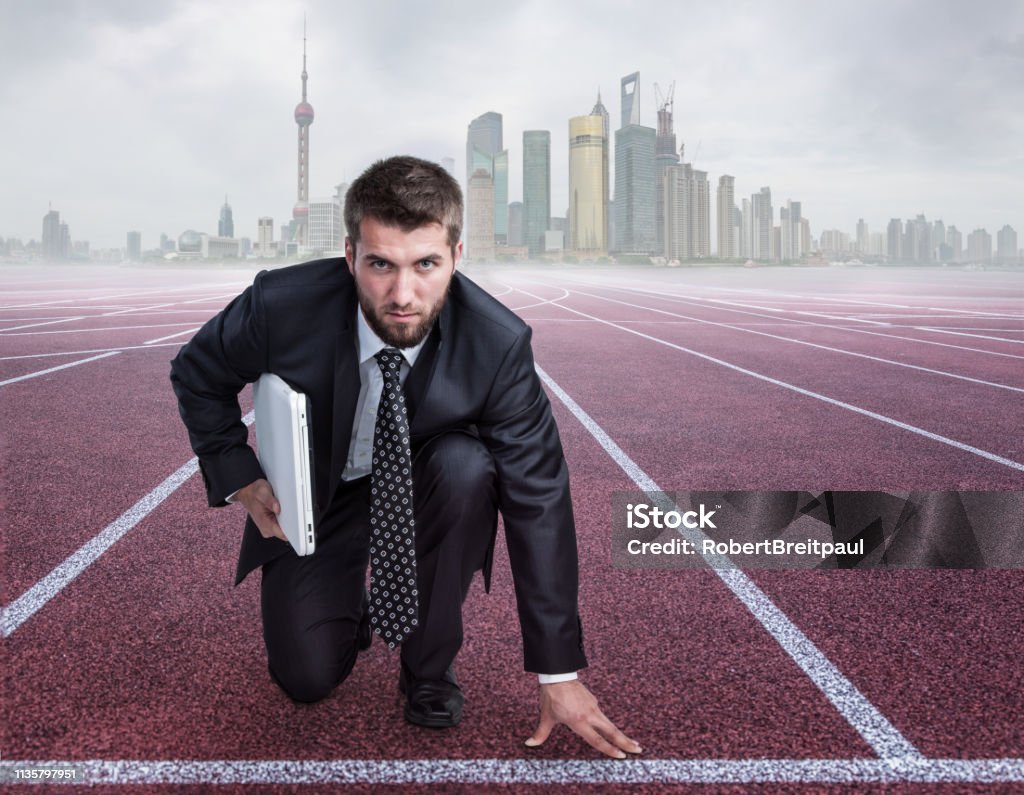 Attractive business man with a note book under his arm on a race track Running Stock Photo