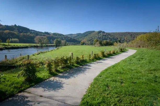 Photo of Small asphalt road beside the Ourthe river in the green Ardennes