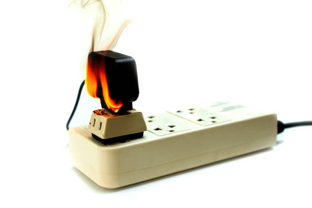 istock On fire electric wire plug Receptacle and adapter on white background, Electric short circuit failure resulting in electricity wire burnt 1135799238