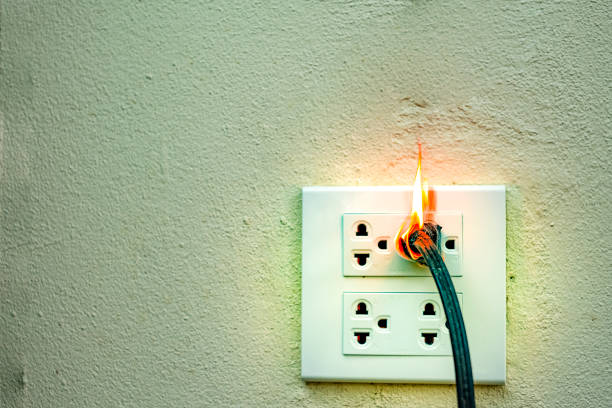 istock On fire electric wire plug Receptacle wall partition,Electric short circuit failure resulting in electricity wire burnt 1135799278