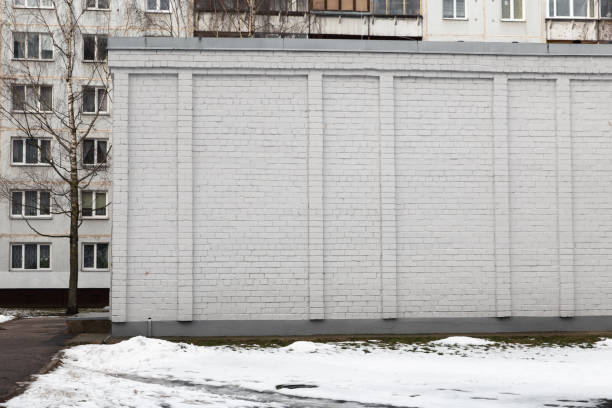 Blank ad space on a white brick wall of a building in the street outside - Whiteboard-like frame for information - plain wall