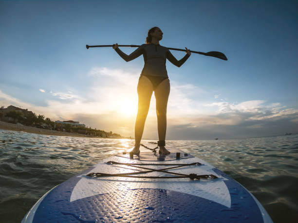istock Woman in wetsuit with a paddle board 1135800694
