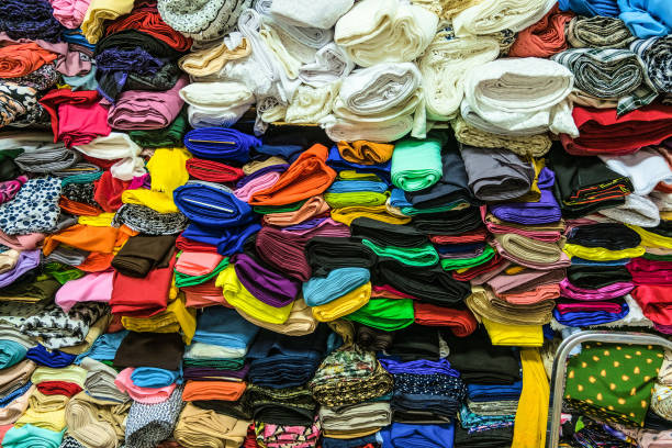 istock Fabric store. Warehouse with stacked colored rolls of fabrics for sewing. 1135800698