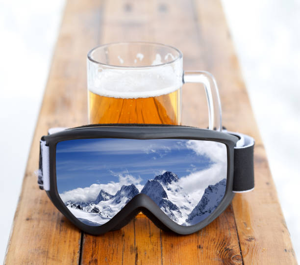 skibrillen mit bergreflektion und glasbecher mit frischem kaltem bier - beer ski apres ski snow stock-fotos und bilder