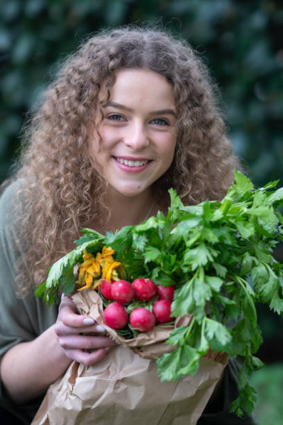 istock Happy young woman holding fresh vegetables 1135804681