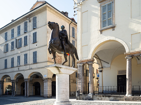 Pavia, Italy - February 22, 2019: monument Regisole near Bishop's Palace palazzo Vescovile on Piazza del Duomo. The statue was restored by Francesco Messina in 1937 according to ancient reproductions