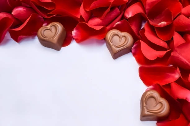 istock Chocolate hearts and red rose petals 1135809411