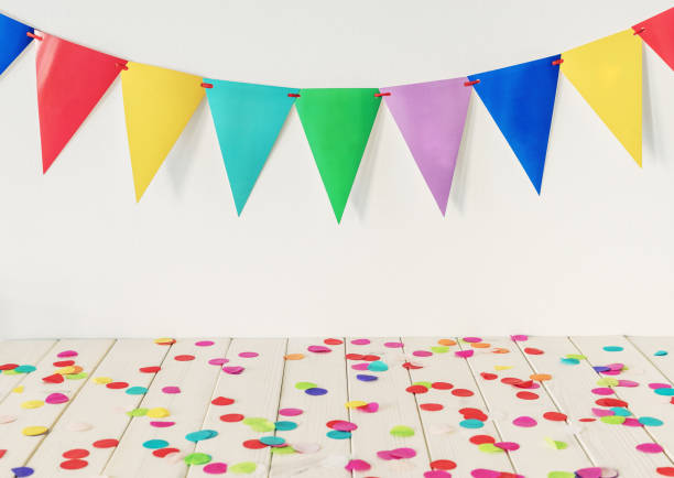 istock Empty wooden table top with colourful confetti and bunting 1135809564