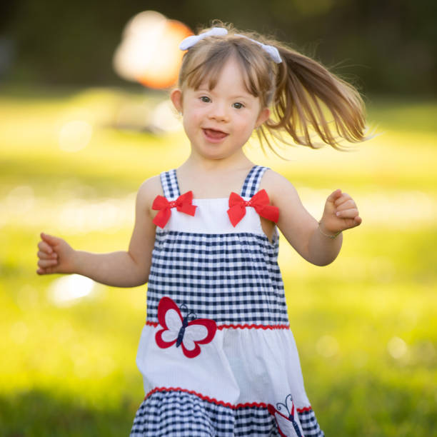 white caucasian blonde young woman with colorful long dress dancing on road in field