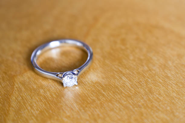 istock Diamond white gold engagement ring on wooden table 1135810779