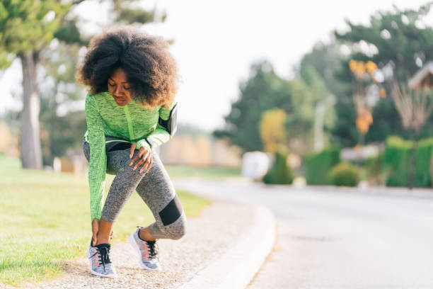 donna africana ferita da sport mentre faceva jogging per strada - twisted ankle immagine foto e immagini stock