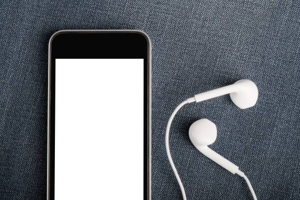 istock Mock up with modern  smartphone and earphones on denim textile. 1135816189
