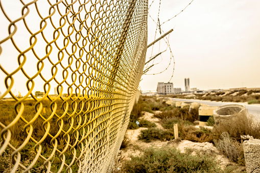 a long and strong fence of border to stop illegal migrants in the middle of desert